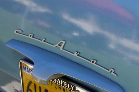 2006 Cadillac STS - Close-up of a chrome script emblem on a vintage car's body panel.