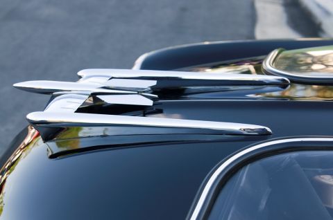 2006 Cadillac STS - Chrome hood ornament with multiple fins on a dark car. Supermotors.net watermark visible.