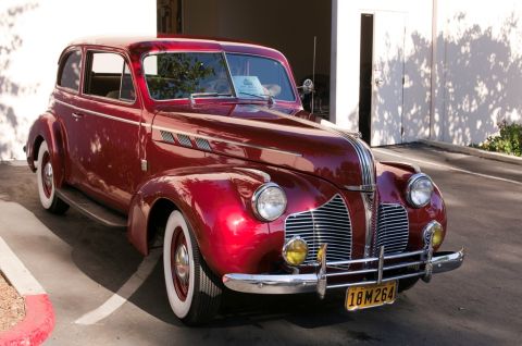 2006 Cadillac STS - This classic red sedan features a distinctive chrome grille and whitewall tires, indicative of a 1939 model.