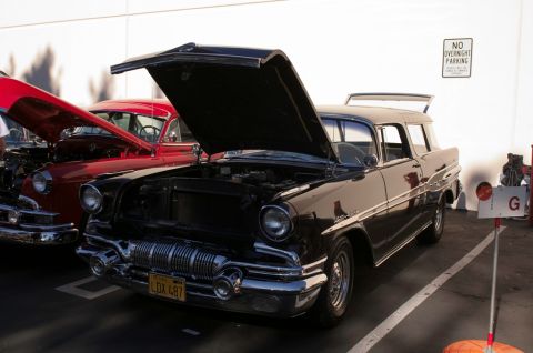 2006 Cadillac STS - Front view of a black 1955 Pontiac station wagon with its hood open at a car show.