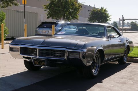 2006 Cadillac STS - A 1969 Buick Riviera is parked outdoors, with another vehicle visible in the background.