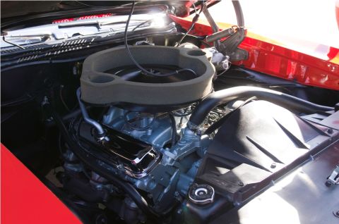 2006 Cadillac STS - Close-up view of a V8 engine, an air cleaner and various hoses and components under the hood of a red vehicle.
