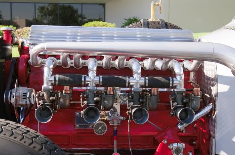 2006 Cadillac STS - Close-up of a custom engine a polished intake manifold and four carburetors, with visible gauges and plumbing.