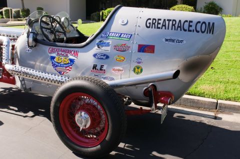 2006 Cadillac STS - A vintage race car is covered in sponsor decals and has 'GREATRACE.COM' written on its tail section.