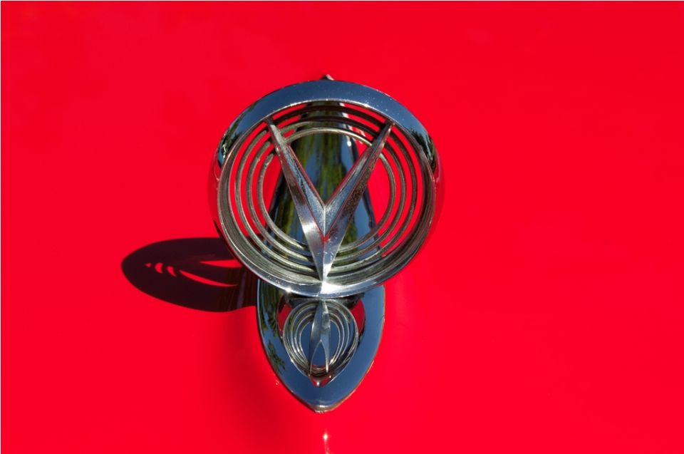 Chrome hood ornament on a red car