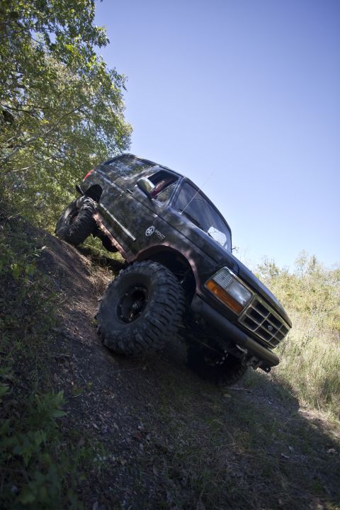 1995 Ford Bronco - Ford Bronco navigating challenging terrain on a sunny day.