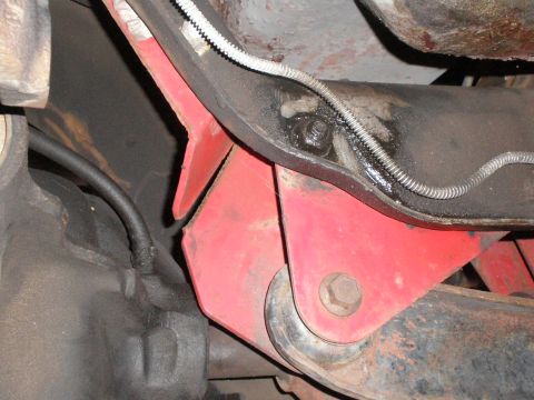 1995 Ford Bronco - Underside view of vehicle frame and suspension parts, showing a red bracket.