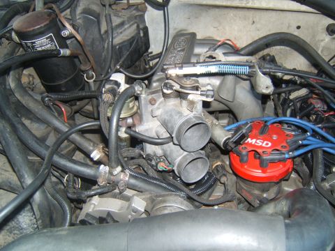 1988 Ford Bronco - Close-up view of an engine bay, focusing on the throttle body and a red MSD ignition distributor.