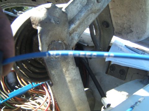 1988 Ford Bronco - A close-up view of wiring in a vehicle's engine bay, with a document visible in the background.