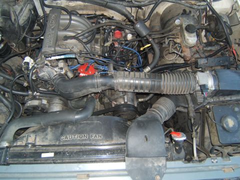 1988 Ford Bronco - Engine bay components, including the radiator shroud with a "CAUTION FAN" warning.