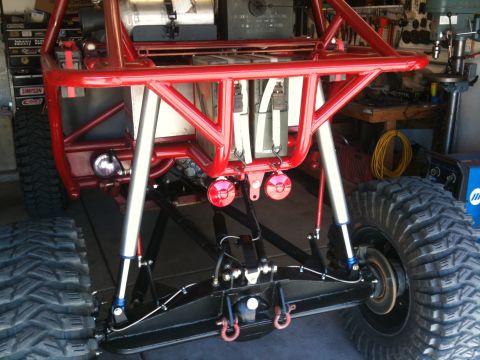 Suzuki Samurai - Custom off-road buggy's rear suspension system large shocks and a red roll cage.