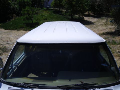 1987 Dodge 1500 - The ribbed roof of a white van is visible from a high angle, looking down through the windshield.