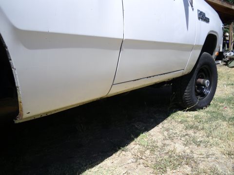 1987 Dodge 1500 - A white pickup truck's side is visible, with a focus on the lower body panels and a wheel.