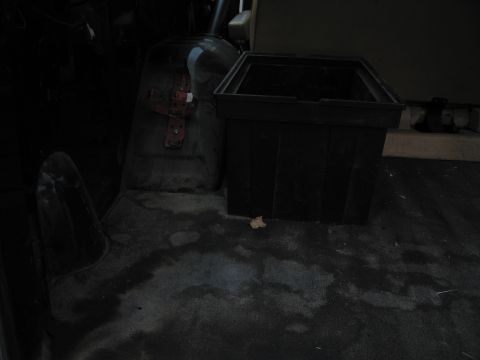 1987 Dodge 1500 - A dark interior shot shows a vehicle seat and a large black storage container on the floor.