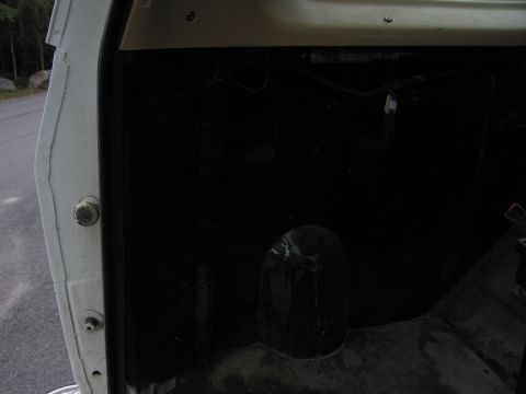 1987 Dodge 1500 - The interior of a white vehicle is shown, with a focus on the black floor and door jamb area.