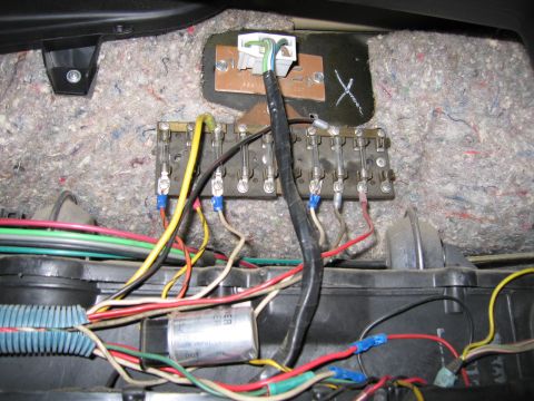 1987 Dodge 1500 - A complex network of wires and a fuse block are visible in this close-up view of a vehicle's interior electrical components.