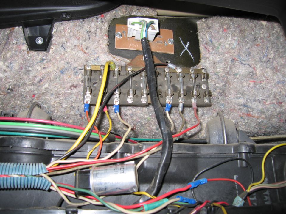 close-up of a car's fuse box and tangled wires