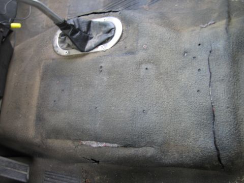 1987 Dodge 1500 - The worn interior floor and gear shifter boot of a vehicle.