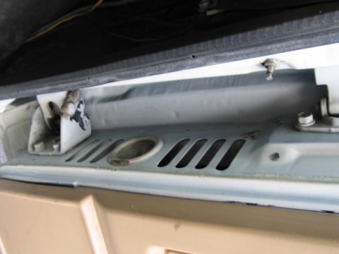 1987 Dodge 1500 - Detail of the engine bay latch mechanism and ventilation slots on a vehicle.