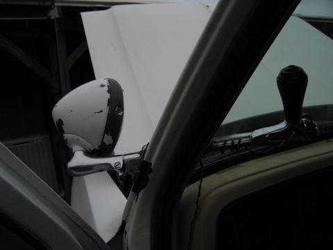 1987 Dodge 1500 - View from inside a truck, showing the side mirror and window crank with the hood up.