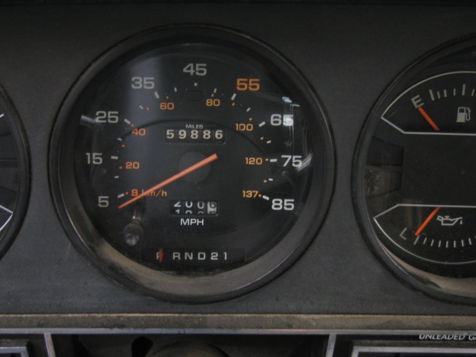 Close-up of a vehicle's dashboard gauges showing odometer reading 59886 miles, speedometer, and fuel gauge