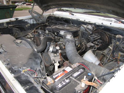 1987 Dodge 1500 - The engine bay of a vehicle, showing various components like the battery, hoses, and air intake system.