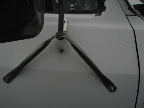 1987 Dodge 1500 - Close-up of a chrome mirror bracket attached to the door of a white vehicle.