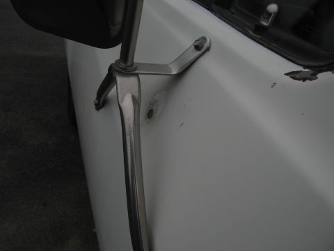 1987 Dodge 1500 - Side mirror mounting bracket on a white vehicle door with visible rust damage.