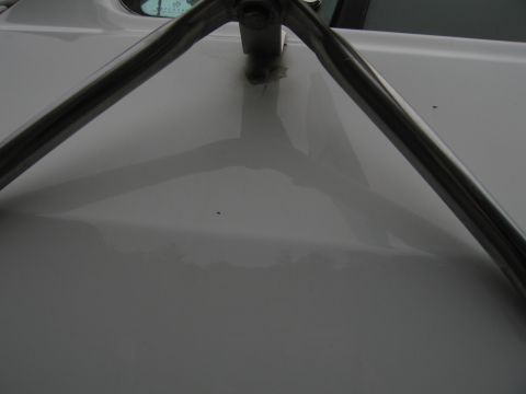 1987 Dodge 1500 - A close-up view of a chrome roll bar attached to the hood of a white vehicle.