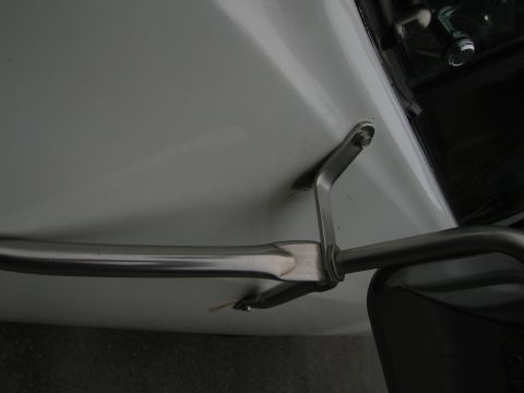 1987 Dodge 1500 - Close-up view of a chrome trim piece and its mounting hardware on a white vehicle.