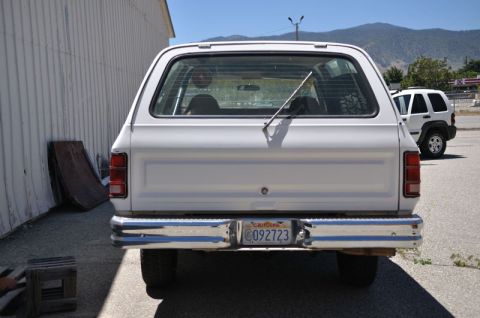 1987 Dodge 1500 - Rear view of a white SUV with a chrome bumper and a California license plate.
