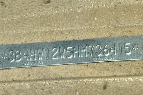1987 Dodge 1500 - Close-up of a VIN plate, showing the vehicle identification number and Chrysler branding.