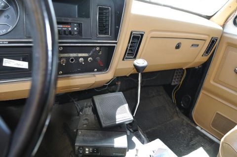 1987 Dodge 1500 - The interior of a truck features a floor shifter, auxiliary switches, and a CB radio mounted on the floor.