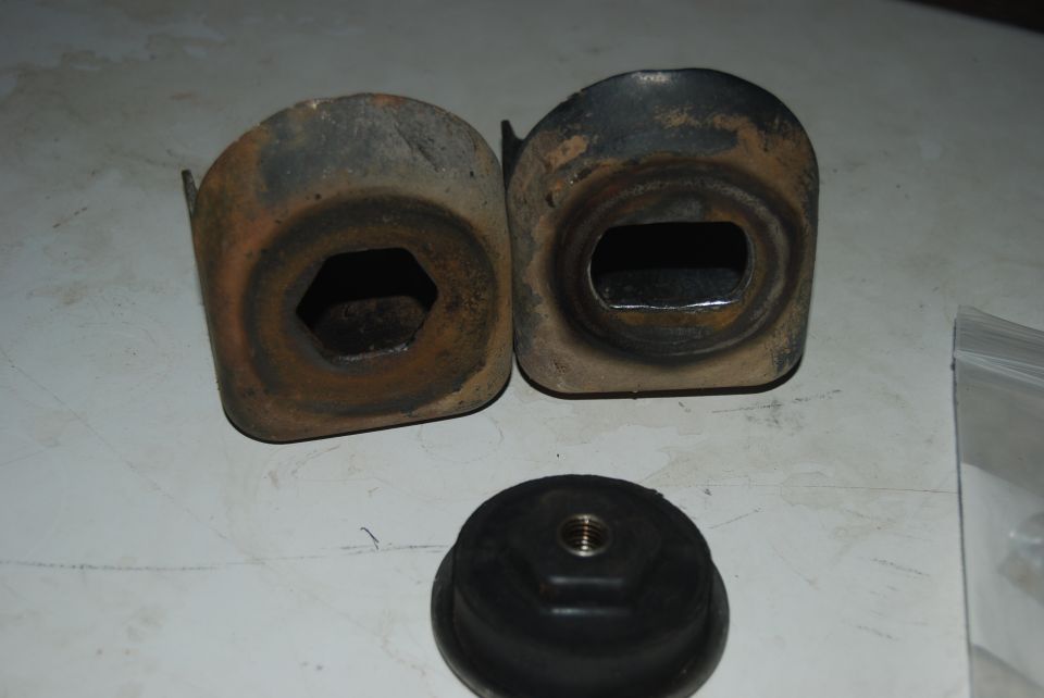 Two rusty metal brackets and a rubber mount