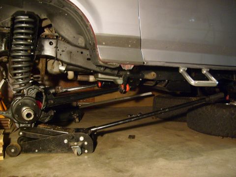 1986 Ford Bronco - Undercarriage view of a 1986 Ford Bronco during suspension work.