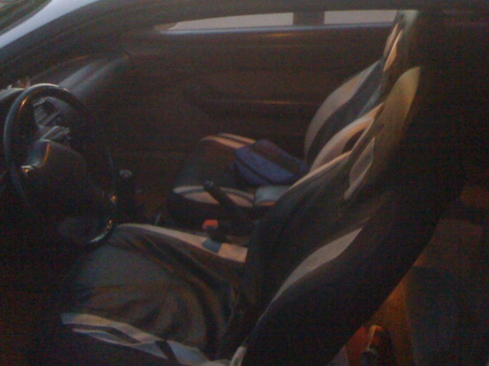 Interior view of car seats and dashboard with 'SUPERMOTORS' watermark
