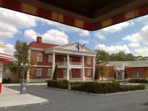 1991 Ford LTD Crown Victoria - A building with a prominent portico and a fountain in front, under a cloudy sky.