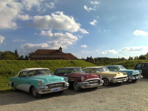 1991 Ford LTD Crown Victoria - A row of classic Buicks, including a teal and white 1955 Century convertible, are parked outdoors under a cloudy sky.