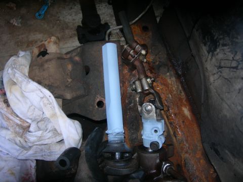 1984 Ford Bronco - Close-up view of vehicle steering column parts and rusty frame components.
