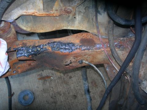 1984 Ford Bronco - Close-up of a corroded vehicle frame showing significant repair work with welding.