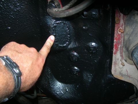 1984 Ford Bronco - A finger points to a section of the vehicle's underbody, which is coated in black paint.