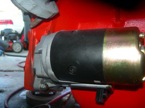 1984 Ford Bronco - A starter motor is mounted to a red engine block, with a watermark indicating the source of the image.