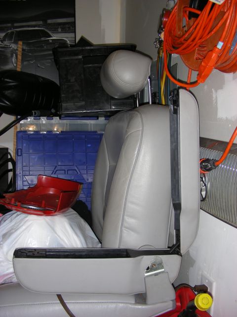 1998 Mercury Grand Marquis - A car seat is shown in a cluttered garage setting, with various storage items and tools visible.