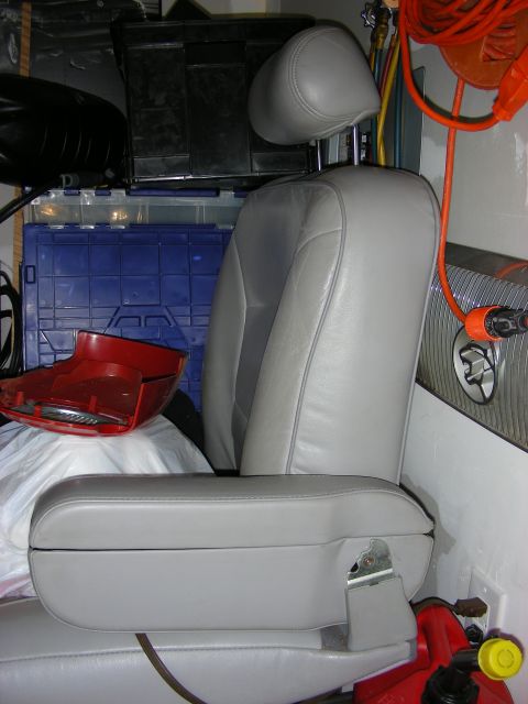 1998 Mercury Grand Marquis - A single car seat is shown in a cluttered garage setting with various storage containers and tools visible.
