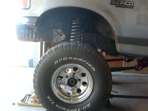 1986 Ford Bronco - Close-up of the front wheel and suspension on a 1986 Ford Bronco XLT.