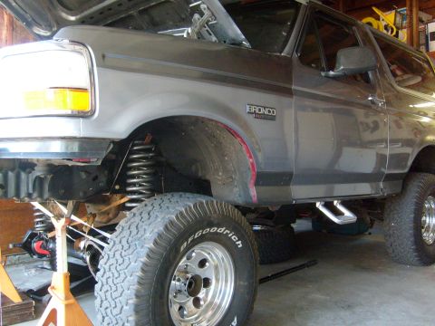 1986 Ford Bronco - This Ford Bronco is undergoing maintenance with its hood open and suspension components visible.