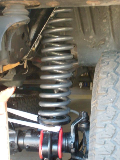 1986 Ford Bronco - Vehicle suspension system detail, showing a coil spring and shock absorber.