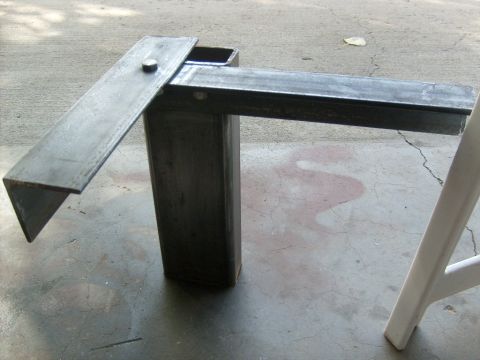 1986 Ford Bronco - A custom metal bracket sits on a concrete surface, possibly a workshop floor.