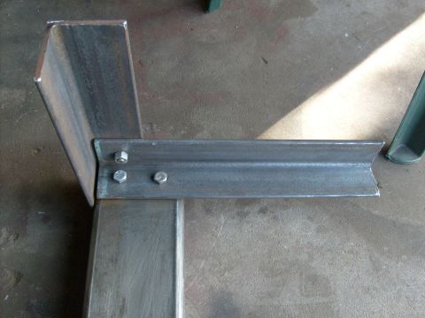 1986 Ford Bronco - Close-up of a metal bracket assembly with visible bolts and raw metal texture.