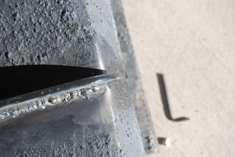 1982 Ford Bronco - A close-up view of a metal component, showing rough texture and weld seams, with an Allen wrench nearby.